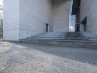 concrete staircase up to a large building with a clock tower in the middle of it