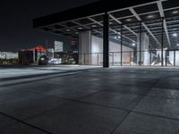 a large building on a dark day with no clouds in the sky at night and the ground is stone