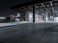 a large building on a dark day with no clouds in the sky at night and the ground is stone