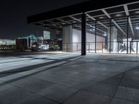 a large building on a dark day with no clouds in the sky at night and the ground is stone