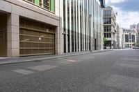 a street with parked cars and lots of tall buildings along it in the city of london