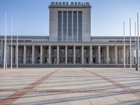 the big building has columns, pillars and a dome with an outdoor clock on top