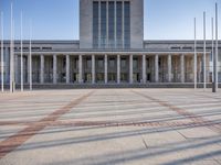 the big building has columns, pillars and a dome with an outdoor clock on top