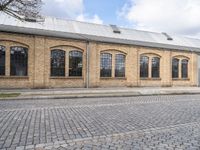 a brick building with many windows on it's sides is in the middle of an alley