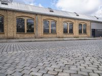 a brick building with many windows on it's sides is in the middle of an alley