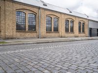 a brick building with many windows on it's sides is in the middle of an alley