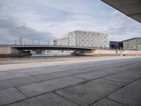 a bridge over a waterway in front of some buildings by the water with people in it