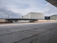 a bridge over a waterway in front of some buildings by the water with people in it