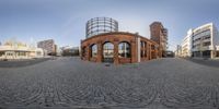 the reflection of an old building in a circle on a pavement in front of a circular building