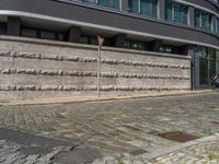 a cobblestone street next to two buildings with street signs on them, on a partly cloudy day