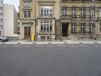 an empty building with signs on the street and people on bikes in traffic passing by