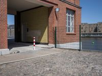 this is a brick building and fenced in area for the gate to be opened