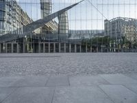 a brick walkway with a large sculpture outside of the building and buildings that line it