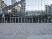 a brick walkway with a large sculpture outside of the building and buildings that line it