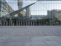 a brick walkway with a large sculpture outside of the building and buildings that line it