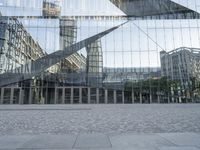 a brick walkway with a large sculpture outside of the building and buildings that line it