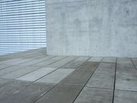 a brick patio area features a white fence with a white wall behind it and lots of light wood trimming on the side of the building