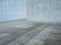 a brick patio area features a white fence with a white wall behind it and lots of light wood trimming on the side of the building