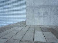 a brick patio area features a white fence with a white wall behind it and lots of light wood trimming on the side of the building
