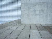 a brick patio area features a white fence with a white wall behind it and lots of light wood trimming on the side of the building