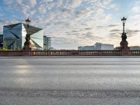 an empty street and a bridge on a cloudy day, with skyscrapers in the background