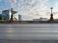 an empty street and a bridge on a cloudy day, with skyscrapers in the background