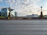 an empty street and a bridge on a cloudy day, with skyscrapers in the background