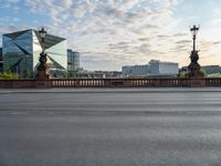 an empty street and a bridge on a cloudy day, with skyscrapers in the background