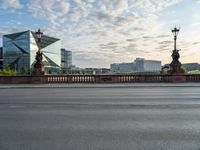 an empty street and a bridge on a cloudy day, with skyscrapers in the background