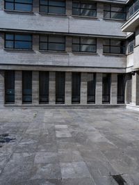 a man walking across a sidewalk in front of a building with multiple balconies