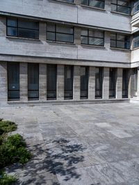 a man walking across a sidewalk in front of a building with multiple balconies