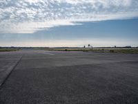 an airplane taking off from an airport tarmac with an arch in the distance and blue skies in the background