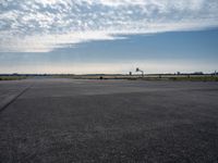 an airplane taking off from an airport tarmac with an arch in the distance and blue skies in the background