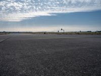 an airplane taking off from an airport tarmac with an arch in the distance and blue skies in the background