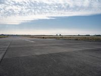 an airplane taking off from an airport tarmac with an arch in the distance and blue skies in the background