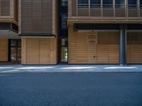 a road through which is a large modern building with an awning over it's entrance