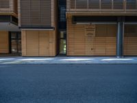 a road through which is a large modern building with an awning over it's entrance