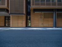 a road through which is a large modern building with an awning over it's entrance