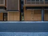 a road through which is a large modern building with an awning over it's entrance