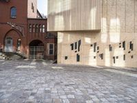 there is a brick walkway with a staircase going up it and three building in the background