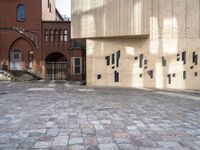 there is a brick walkway with a staircase going up it and three building in the background