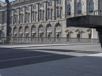 the empty bench sits at the edge of the street in front of the city hall