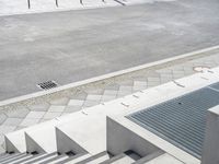 a skateboarder is in the middle of an empty street and another is riding down it