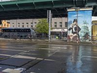 a city bus is driving under a bridge above water, and another bus rides under the bridge