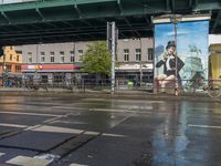 a city bus is driving under a bridge above water, and another bus rides under the bridge