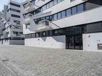 a parking garage in the courtyard between two buildings with one car parked on the side and another behind