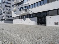 a parking garage in the courtyard between two buildings with one car parked on the side and another behind