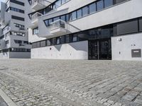 a parking garage in the courtyard between two buildings with one car parked on the side and another behind