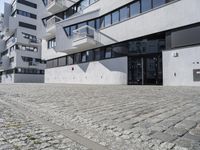 a parking garage in the courtyard between two buildings with one car parked on the side and another behind