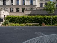 a bench is sitting in the middle of a street with buildings and trees around it